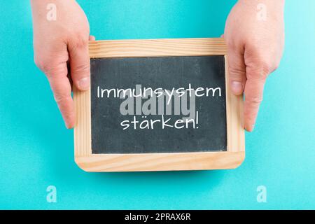 Strengthen the immune system is standing in german language on a chalkboard, healthy eating and lifestyle concept, natural protection from disease Stock Photo