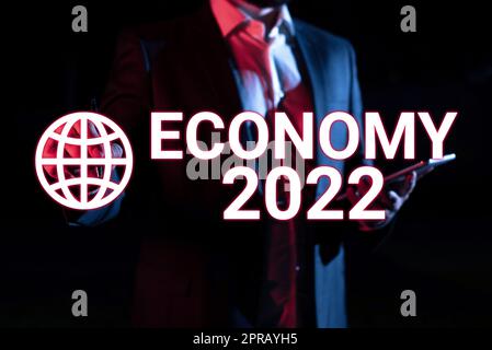 Text showing inspiration Economy 2022. Conceptual photo State of wealth and resources of a country in upcoming year Businessman Holding Tablet And Pointing With Pen On Important Message. Stock Photo