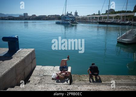 Malaga, Spain. 26th Apr, 2023. A woman is seen sunbathing at 'Muelle Uno' promenade as she enjoys the good weather amid an unusual heat wave. Spain is experiencing an unusual episode of high temperatures in April, months before the beginning of summer. According to the Spanish State Meteorological Agency, temperatures of over 35 degrees will be reached in most of the country. (Photo by Jesus Merida/SOPA Images/Sipa USA) Credit: Sipa USA/Alamy Live News Stock Photo