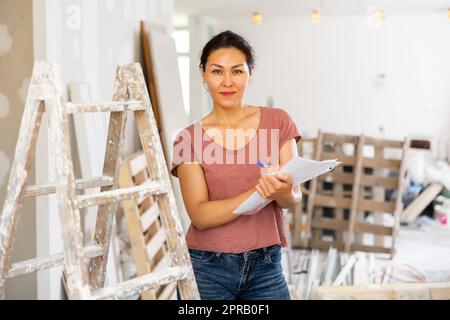 Portrait of positive woman construction manager with documents Stock Photo
