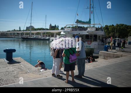 Malaga, Spain. 26th Apr, 2023. A group of women, who are using an umbrella to protect themselves from the sun, are seen at the 'Muelle Uno' promenade during an unusual heat wave. Spain is experiencing an unusual episode of high temperatures in April, months before the beginning of summer. According to the Spanish State Meteorological Agency, temperatures of over 35 degrees will be reached in most of the country. (Credit Image: © Jesus Merida/SOPA Images via ZUMA Press Wire) EDITORIAL USAGE ONLY! Not for Commercial USAGE! Stock Photo