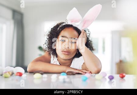 One grumpy little easter bunny. a unhappy girl sitting at home. Stock Photo
