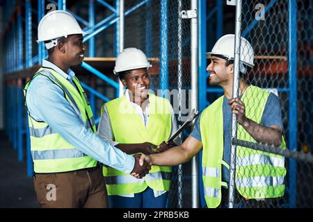 To build the best, work with the best. builders shaking hands at a construction site. Stock Photo