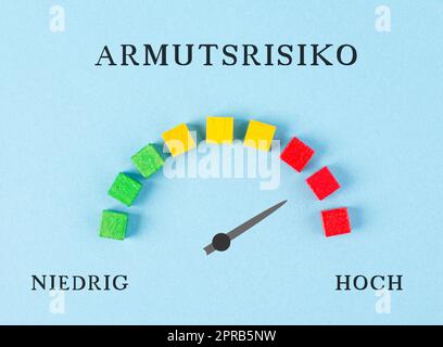 The words risk for poverty are standing in german language over the loading bar, high and low stands below, the pointer indicates to the red area, inflation and recession concept Stock Photo