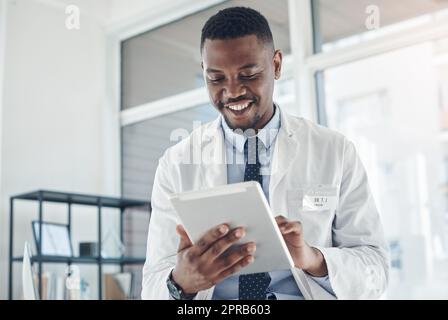 Find a job thats fulfilling. a young doctor using a digital tablet in an office. Stock Photo