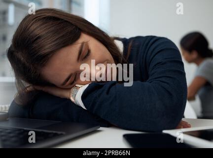 Just a little break. a young businesswoman taking a nap at her desk in her office. Stock Photo