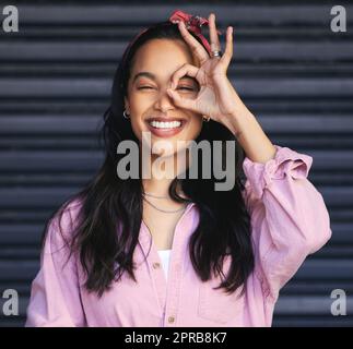 How do I look. Cropped portrait of an attractive young woman posing playfully against a grey background. Stock Photo