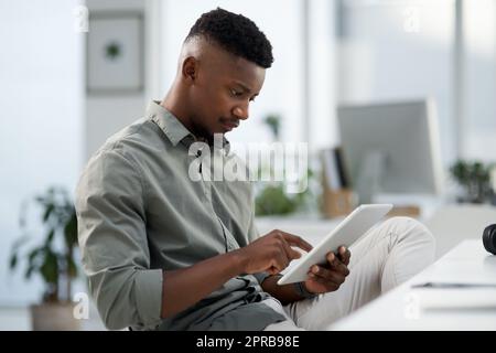 100 focused on todays target. a young businessman working on a computer in an office. Stock Photo