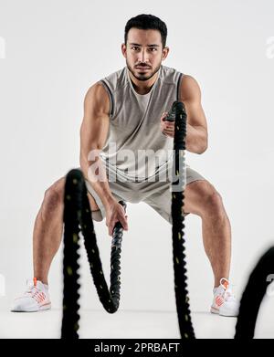 Men with combat rope fighting ropes exercise in the fitness gym. Crossfit  Stock Photo by StudioPeace