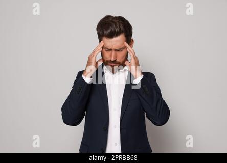 Worried bearded man on light grey background Stock Photo