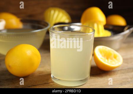 Freshly squeezed lemon juice on wooden table Stock Photo