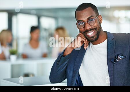 Confident, happy and smiling creative man standing in the office with a team of marketing agents in background. Portrait of cheerful, motivated and proud designer ready for success in startup company Stock Photo