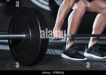 Get a grip on good health. an unrecognisable man lifting a barbell during his workout at a gym. Stock Photo