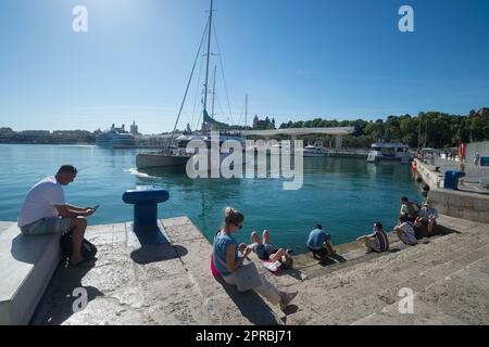 Malaga, Spain. 26th Apr, 2023. People are seen resting at 'Muelle Uno' promenade as they enjoy the good weather amid an unusual heat wave. Spain is experiencing an unusual episode of high temperatures in April, months before the beginning of summer. According to the Spanish State Meteorological Agency, temperatures of over 35 degrees will be reached in most of the country. (Credit Image: © Jesus Merida/SOPA Images via ZUMA Press Wire) EDITORIAL USAGE ONLY! Not for Commercial USAGE! Stock Photo