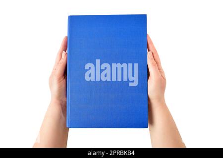 Female hands holding closed book with blue cover on light background Stock Photo