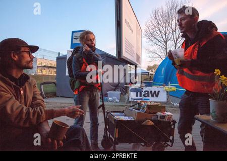 Aid workers discuss the amount of Ukranian refugees in line to cross into poland from Shehyni Ukraine. Stock Photo