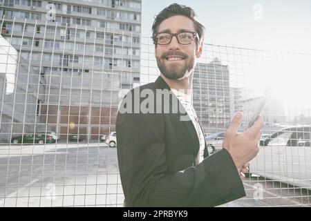 Enjoying city life. a stylish young man using his cellphone while out walking in the city. Stock Photo