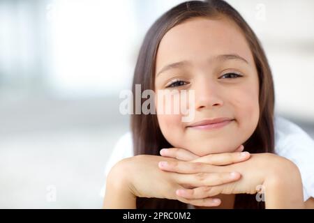 Innocence personified. A portrait of cute girl with her face resting on her hands. Stock Photo