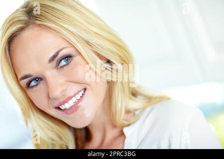 Showing off her best smile. Cropped head and shoulders portrait of a pretty blonde woman smiling. Stock Photo