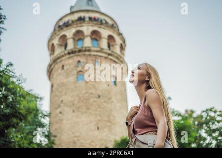 Portrait of beautiful woman tourist with view of Galata tower in Beyoglu, Istanbul, Turkey. Turkiye Stock Photo