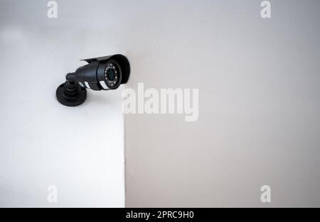 CCTV cameras installed on a white wall. Concept of surveillance and monitoring. Stock Photo