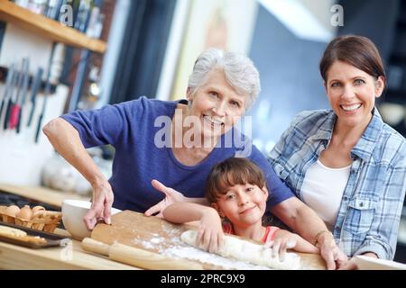 Looks like shes a pro. Portrait of a three generational family baking together. Stock Photo