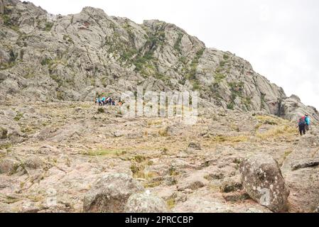 Los Gigantes, Cordoba, Argentina, April 6, 2023: A group of mountaineers are hiking up a trail amidst a rocky mountainous landscape, an ideal tourist Stock Photo