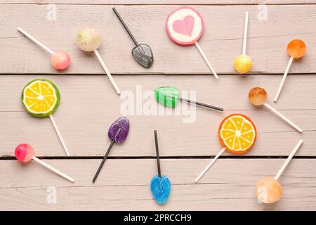 Different sweet lollipops on white wooden table Stock Photo