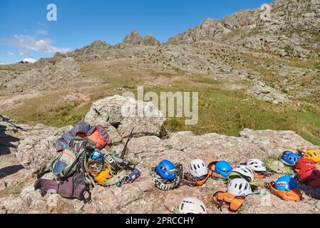 Los Gigantes, Cordoba, Argentina, April 6, 2023: Climbing equipment for a group of mountaineers, harnesses and helmets, in a rocky mountainous scenery Stock Photo