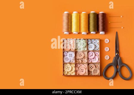 Composition with different thread spools and sewing supplies on color background Stock Photo