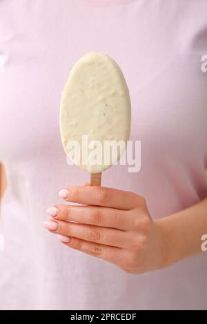 Woman holding delicious chocolate covered ice cream on stick against ...