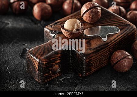 Opened Nuts Of Macadamia On Little Vintage Chopping Board Stock Photo