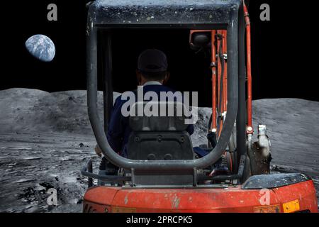 A man works with a digger on the moon Stock Photo