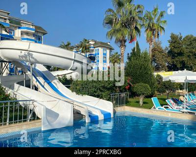 A beautiful aqua park with water slides and natural palm trees in a hotel in a warm tropical southern country resort. Stock Photo