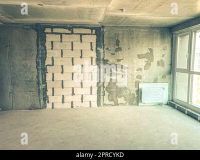 apartment without finishing and repair. concrete block walls with panoramic windows. a battery is attached to the walls. walls prepared for applicatio Stock Photo