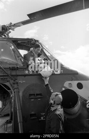 File photo dated 09/09/74 of Naval Lieutenant the Prince of Wales being handed his flying helmet by a ground crewman before going up for his first &quot;dual control&quot; flight with instructor Lieutenant Commander Alan MacGregor in a Royal Navy Wessex V helicopter. Photos from every year of the King's life have been compiled by the PA news agency, to celebrate Charles III's coronation. Issue date: Thursday April 27, 2023. Stock Photo