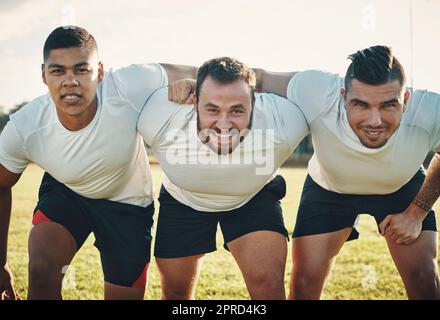 You know what were here for. Cropped portrait of a group of three young rugby players lining up for a scrum on the field during the day. Stock Photo