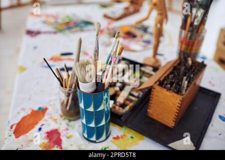 Pick up a brush and start painting. Still life shot of paintbrushes lying on the floor in a art studio. Stock Photo