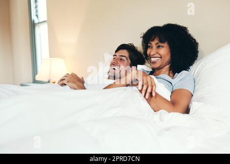 Were staying in this weekend. an affectionate young couple spending some quality time together in their bedroom at home. Stock Photo