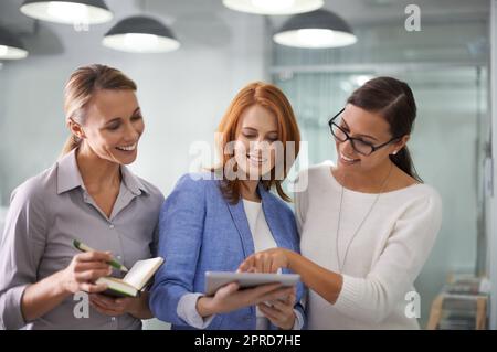 Creative team of women with tablet planning ideas, brainstorming strategy and sharing ideas in office. Manager, boss and leader asking colleagues for help on technology or training staff on new plan Stock Photo