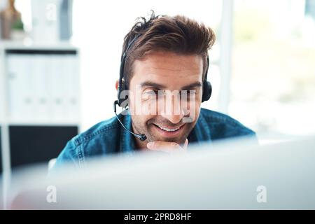 Hes got a knack of securing the biggest deals. an attractive young call centre agent working in his office. Stock Photo