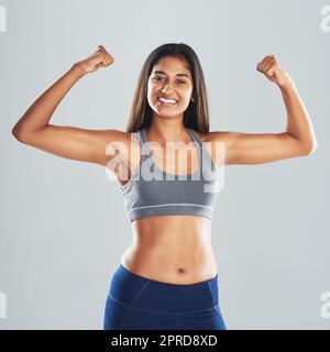 Portrait of a young woman flexing her muscles Stock Photo - Alamy
