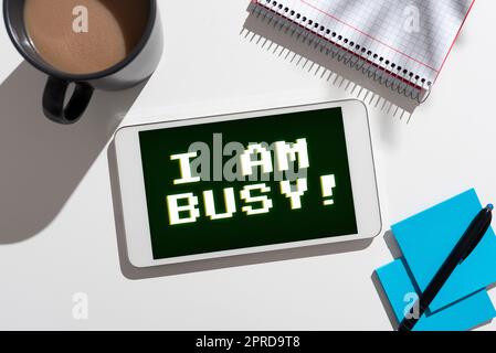 Handwriting text I Am Busy. Business idea To have a lot of work to do Stressed out no time for leisure Important Messages Tablet On Desk With Pen, Notebook, Cup And Notes. Stock Photo