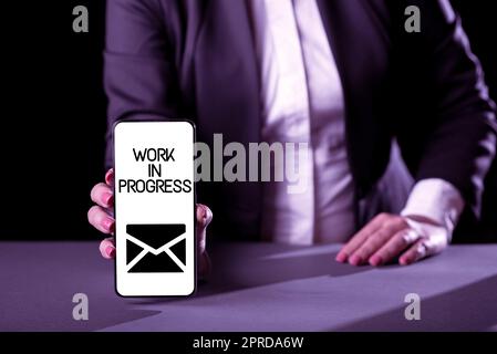 Text sign showing Work In Progress. Concept meaning Job still being done developing project business strategy Businesswoman Holding Phone And Presenting Important Informations On Screen Stock Photo