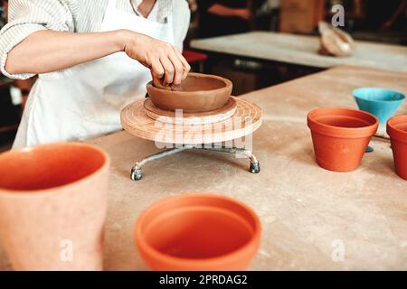 Its not just a bowl, its art. an unrecognizable woman shaping a clay pot in her workshop. Stock Photo