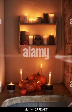 The scarier the better. Still life shot of carved pumpkins and lit candles placed together in celebration of halloween. Stock Photo