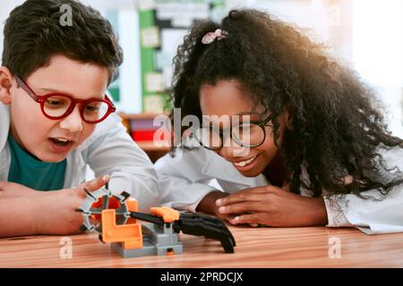 Can you believe we built this. an adorable little boy and girl building a robot in science class at school. Stock Photo