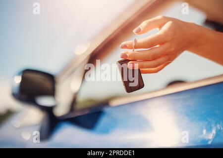 Woman's hand holding key from her new car Stock Photo