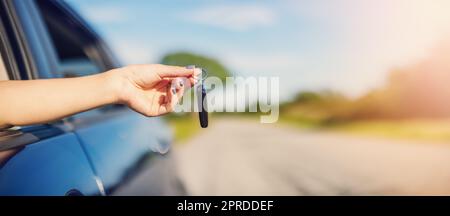 Woman's hand holding key from her new car Stock Photo