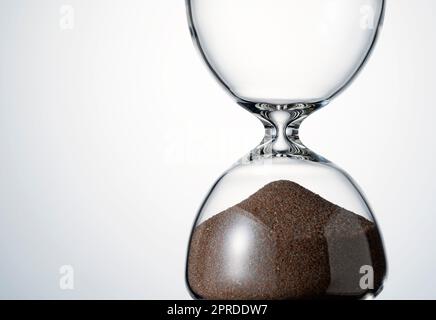 An hourglass placed on a white background. Stock Photo